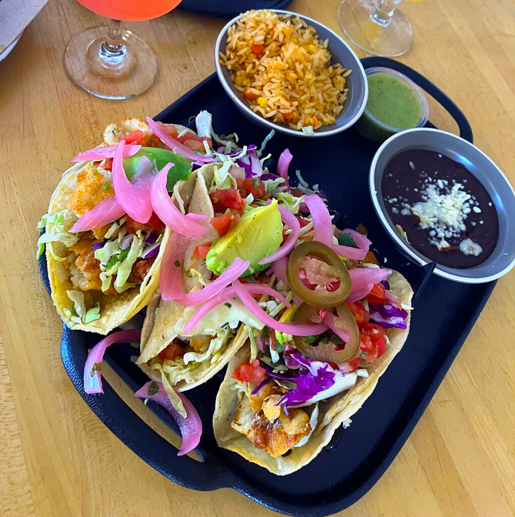 A plate of delicious tacos and a bowl of zesty salsa