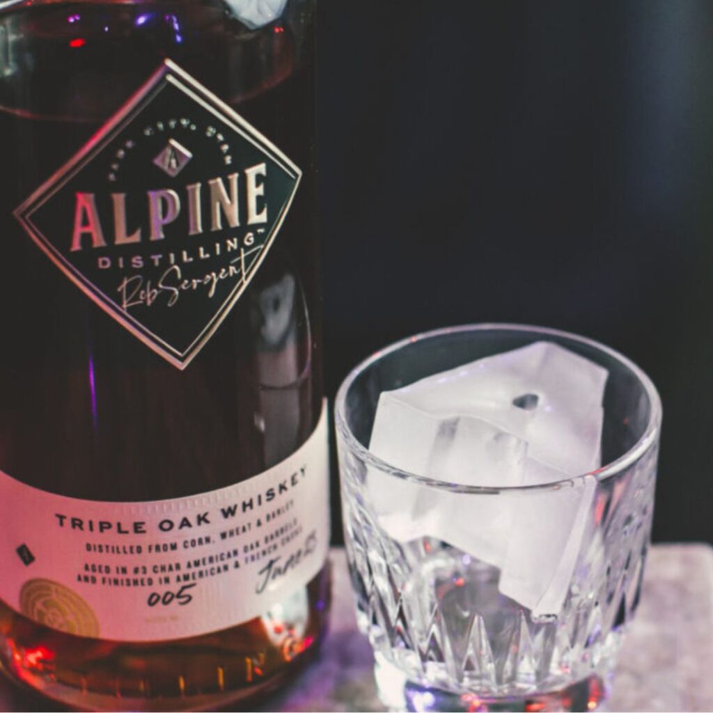 Alpine Distilling beverage with a glass