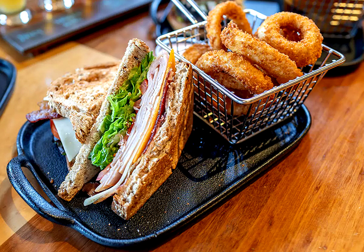 A tray with a sandwich and onion rings