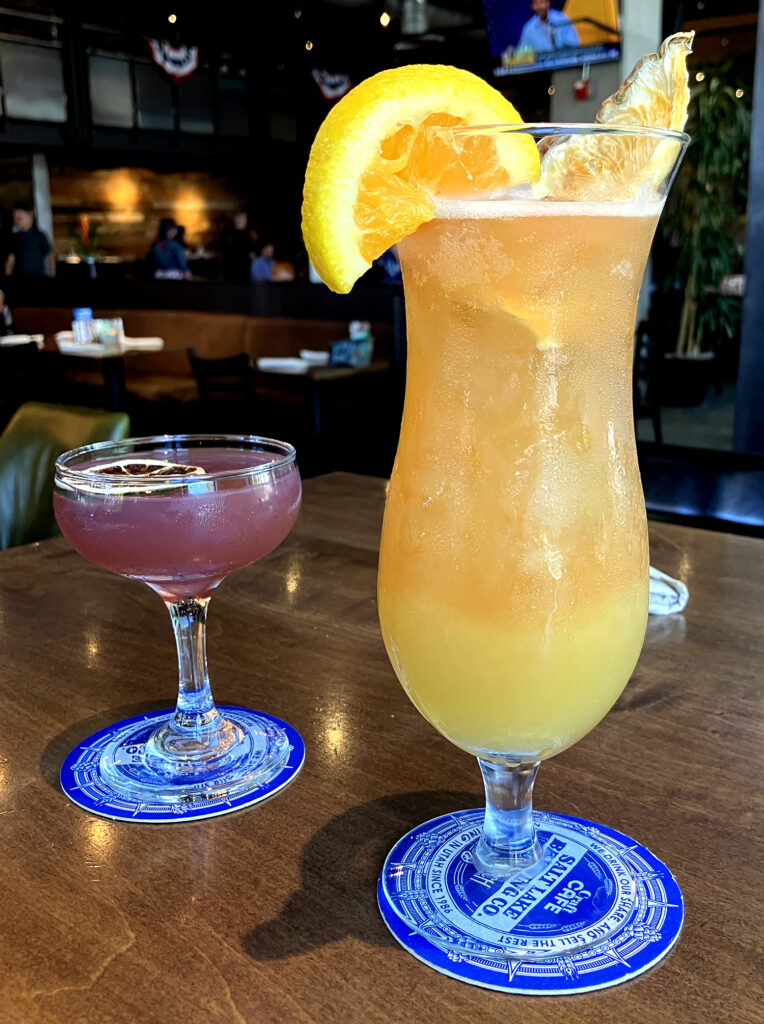 two glasses of refreshing beverages displayed on a rustic wooden table