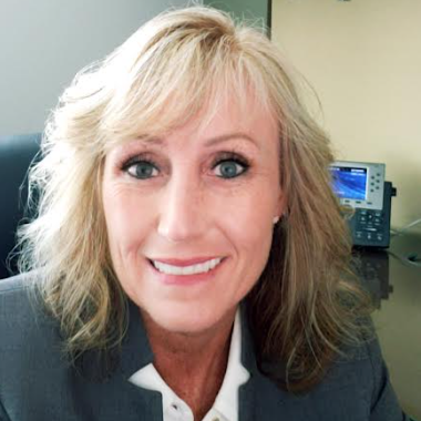 A woman with blonde hair sitting in an office chair