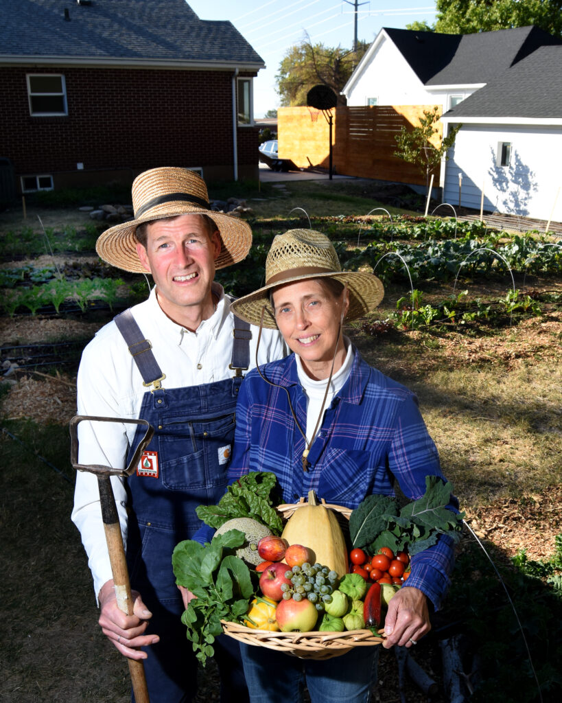 A couple holding a basket of fresh vegetables