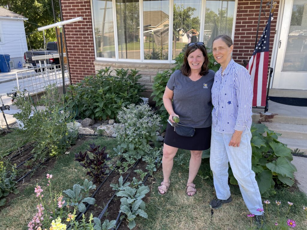 Two friends posing together in front of a house