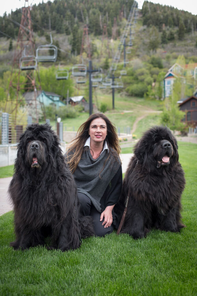 A woman enjoying the outdoors with her three dogs