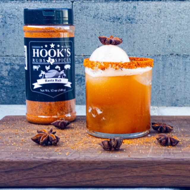 A glass of whiskey beside a bottle of bourbon