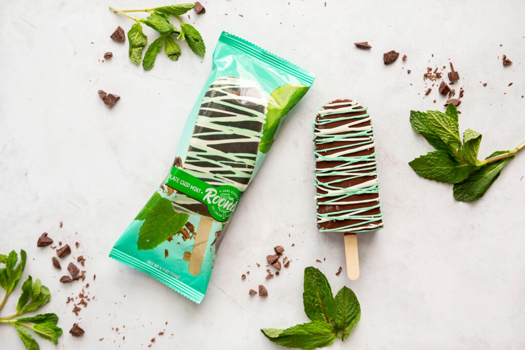 A bag of mint chocolate pops next to some mint leaves