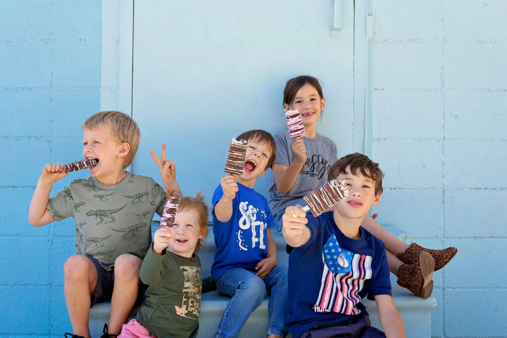 A group of children happily sitting on a bench in the park