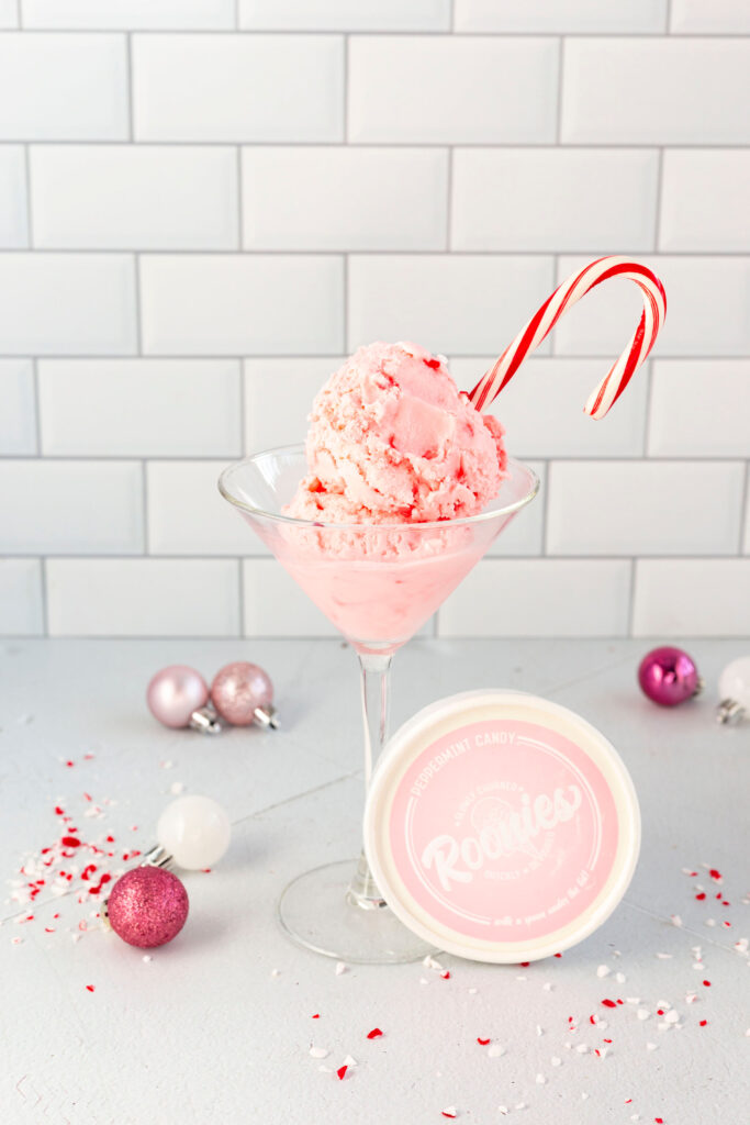 A pink ice cream sundae with a candy cane in it