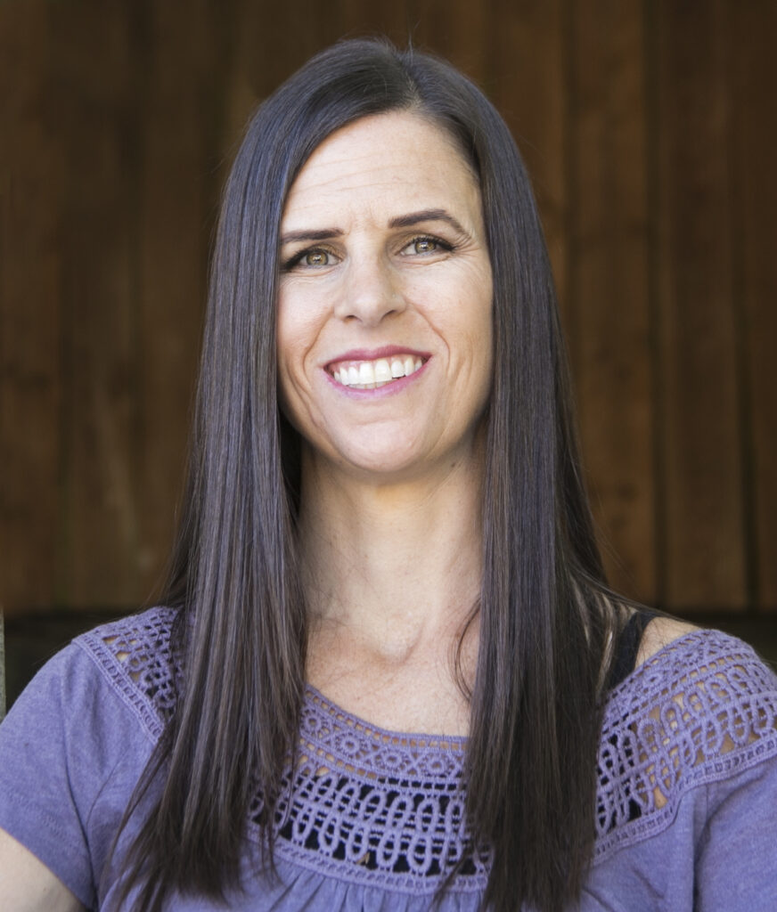 A woman with long black hair smiling at the camera