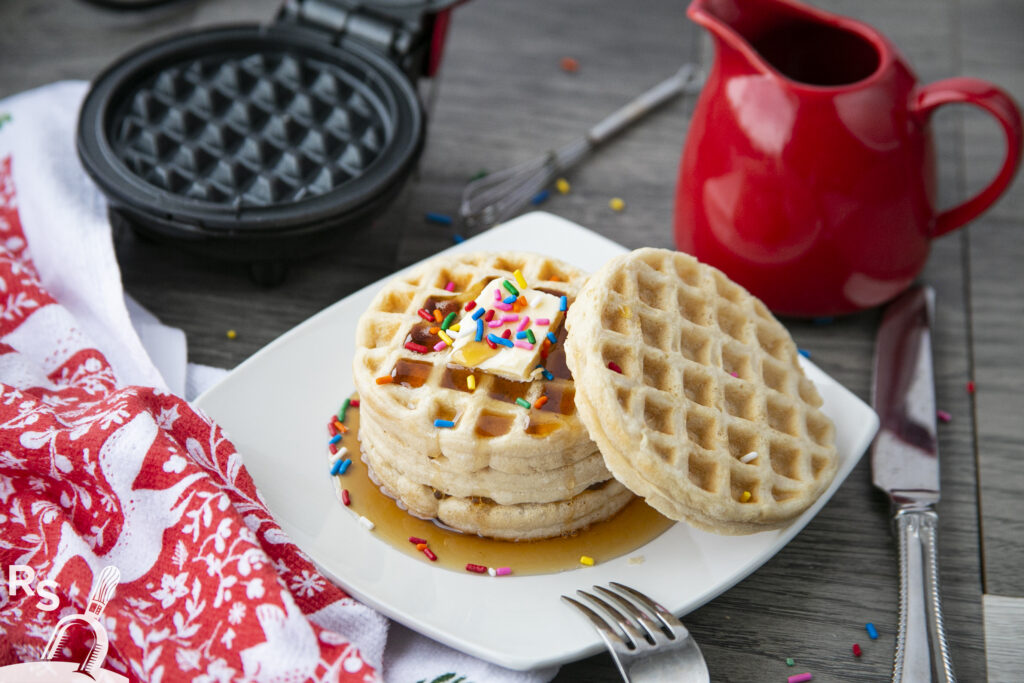 two waffles on a plate with syrup and sprinkles, perfect for a delightful breakfast treat