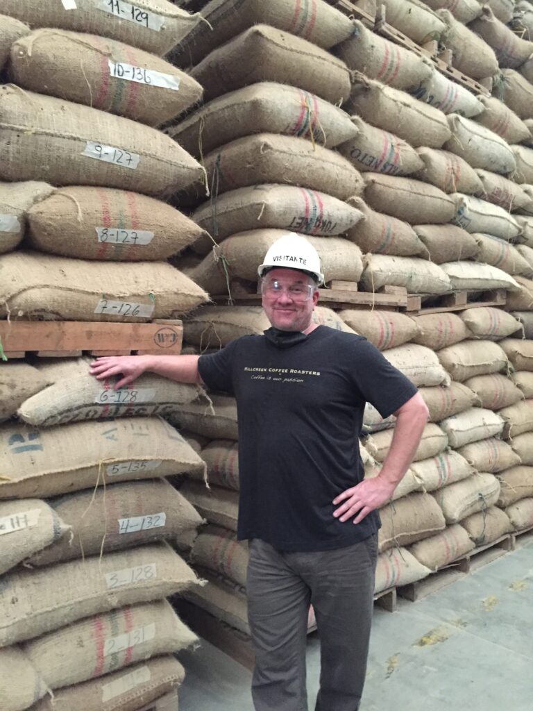 A man standing in front of a pile of bags