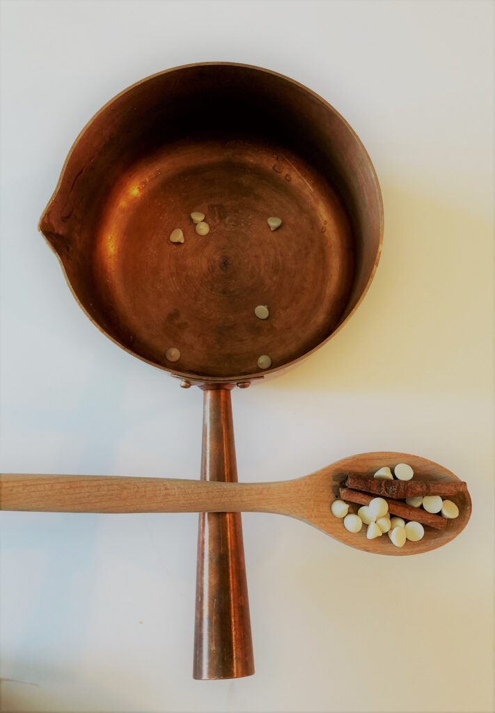 A wooden spoon and spoon rest on a white surface