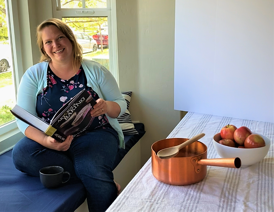 A woman sitting at a table holding a book