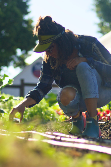 woman kneeling down planting seeds in a garden