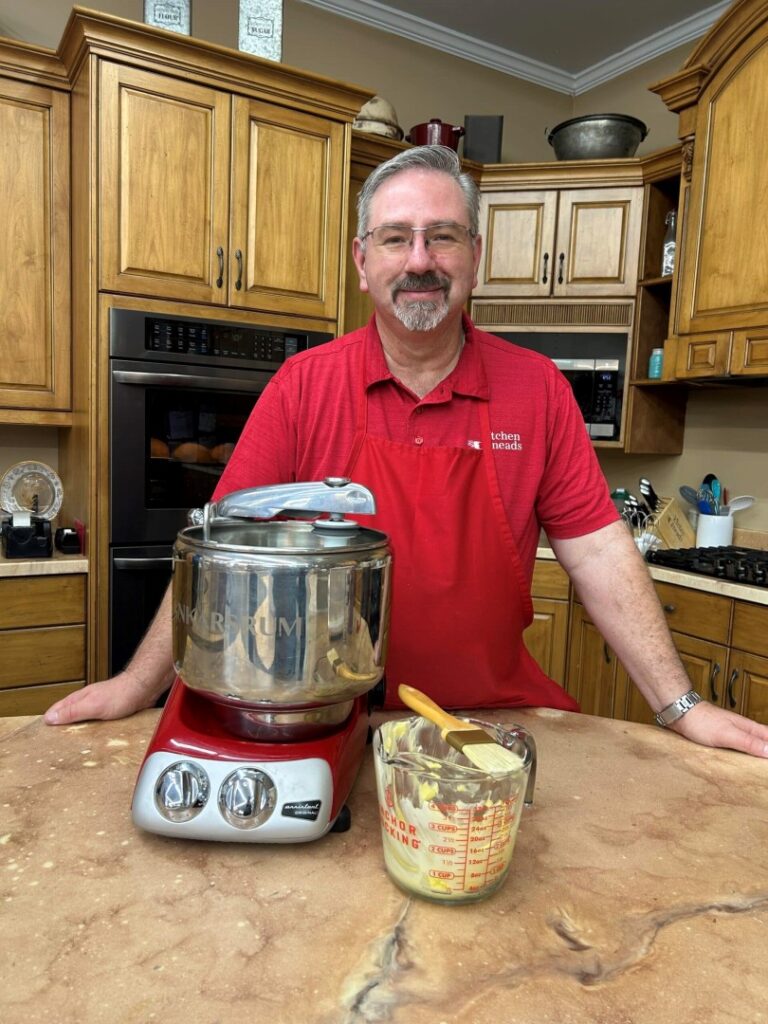 a man stands at a counter behind a kitchen appliance