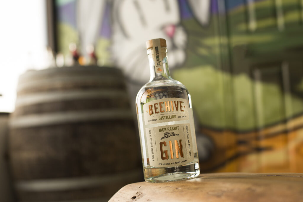 A bottle of whiskey resting on a wooden barrel