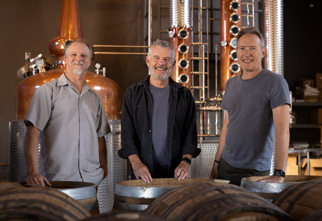 three men enjoying a wine tasting experience at a winery