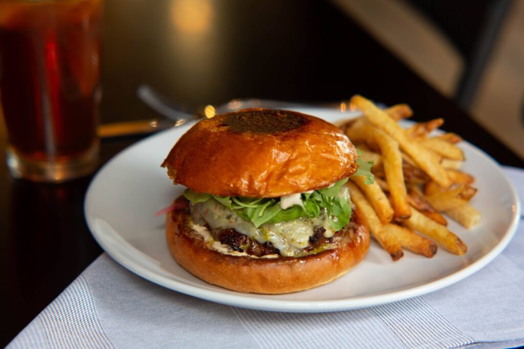 A classic hamburger and crispy french fries on a clean white plate