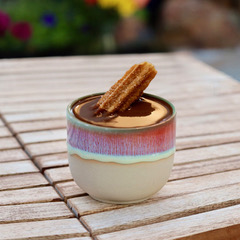 Drinking chocolate in cup with churro