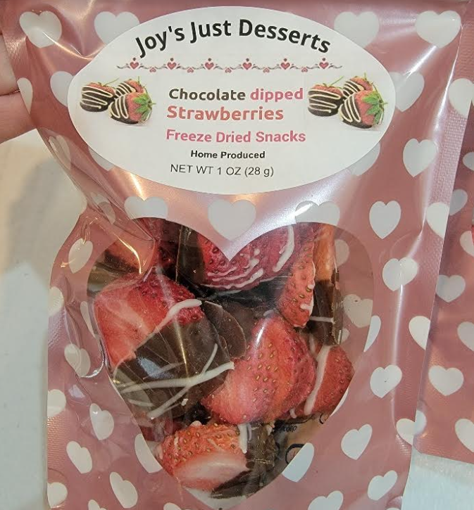 A bag of chocolate dipped strawberries in a pink polka dot bag