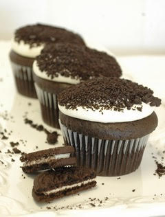 A white plate filled with chocolate frosted cupcakes