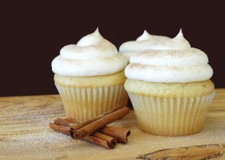 a couple of cupcakes displayed on a rustic wooden table