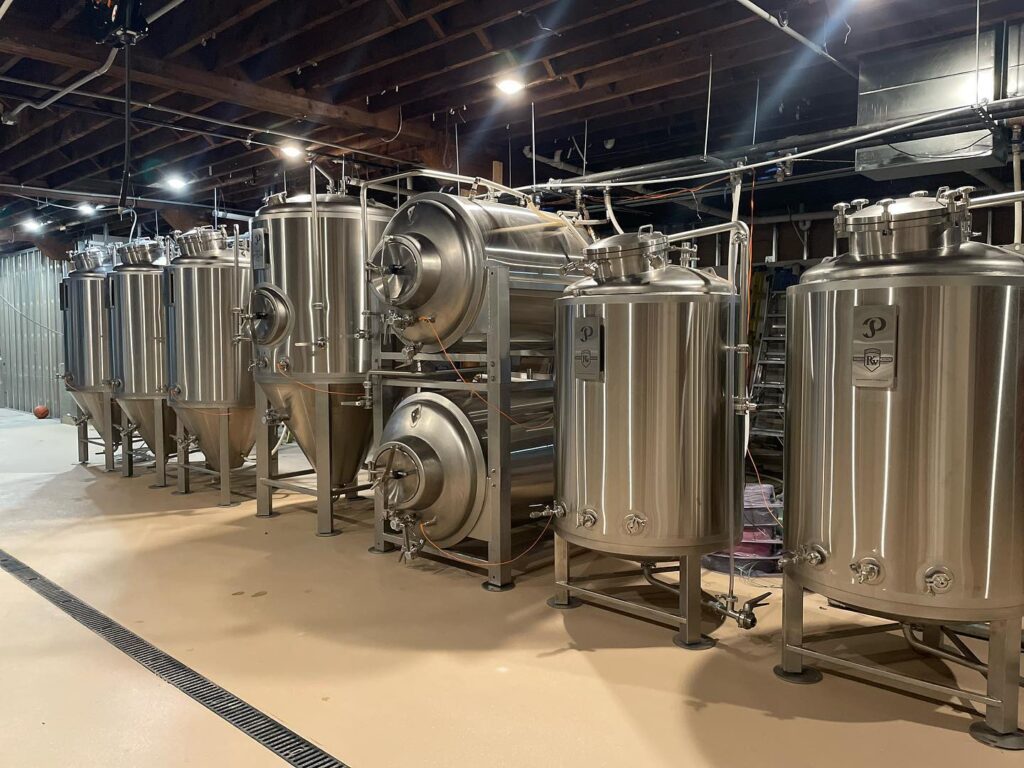 stainless steel tanks lined up in a warehouse