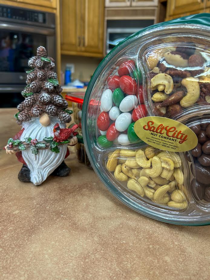 A glass bowl filled with assorted nuts on top of a counter