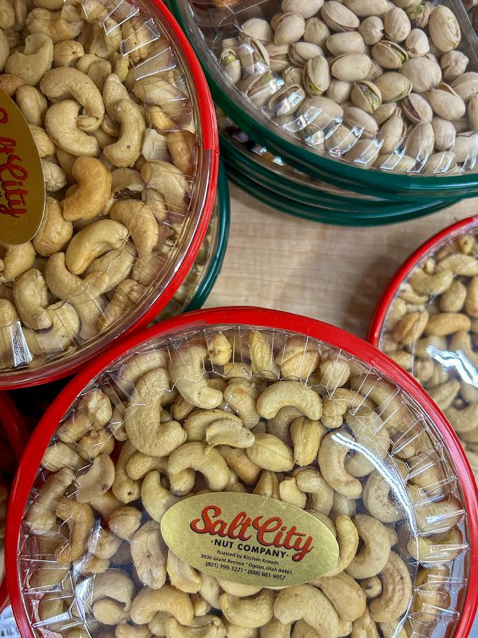 Three vibrant red bowls overflowing with roasted cashews